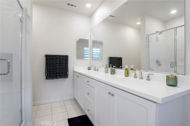 full bath featuring tile patterned floors, double vanity, a sink, visible vents, and a stall shower