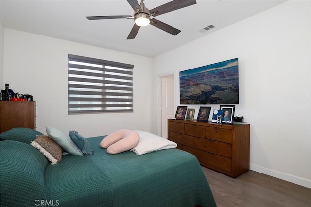 bedroom featuring visible vents, ceiling fan, wood finished floors, and baseboards