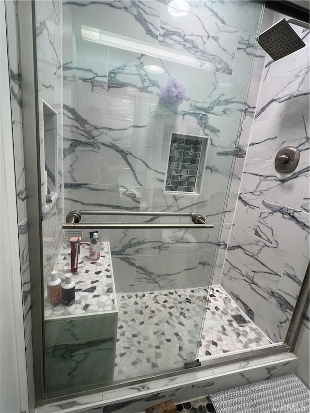 bathroom featuring a marble finish shower