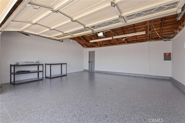 garage with baseboards, a garage door opener, and electric panel