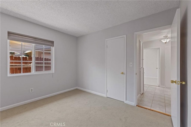 empty room featuring baseboards, carpet flooring, and a textured ceiling