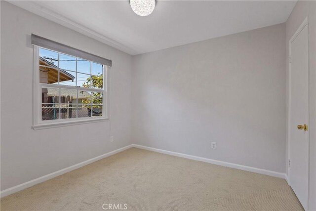 carpeted empty room featuring baseboards