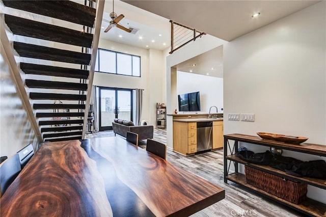 dining area featuring stairway, a ceiling fan, light wood finished floors, and recessed lighting