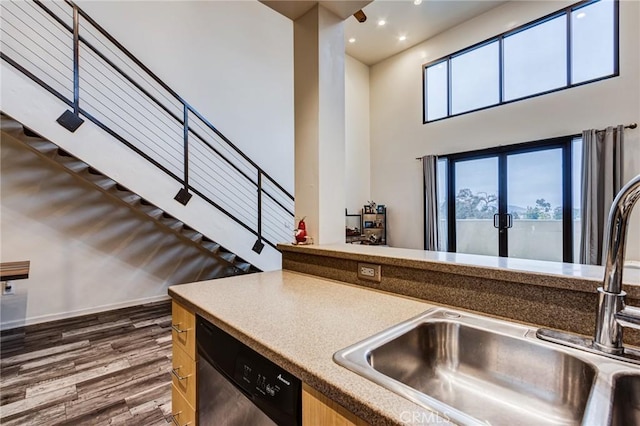 kitchen with recessed lighting, dishwasher, a sink, dark wood-style floors, and a towering ceiling