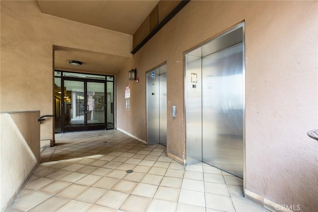 corridor featuring light tile patterned floors and elevator