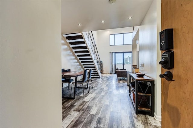 entrance foyer featuring a high ceiling, wood finished floors, and stairs