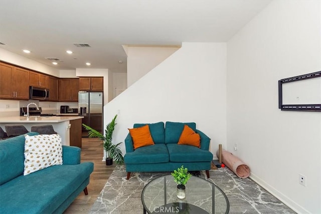 living area with recessed lighting, baseboards, visible vents, and light wood-style flooring