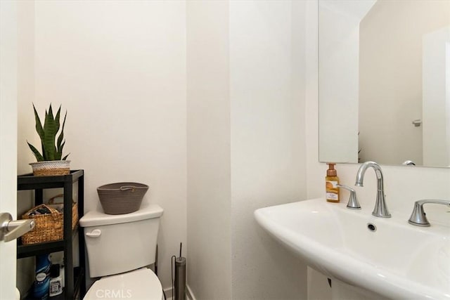 half bath featuring a sink and toilet