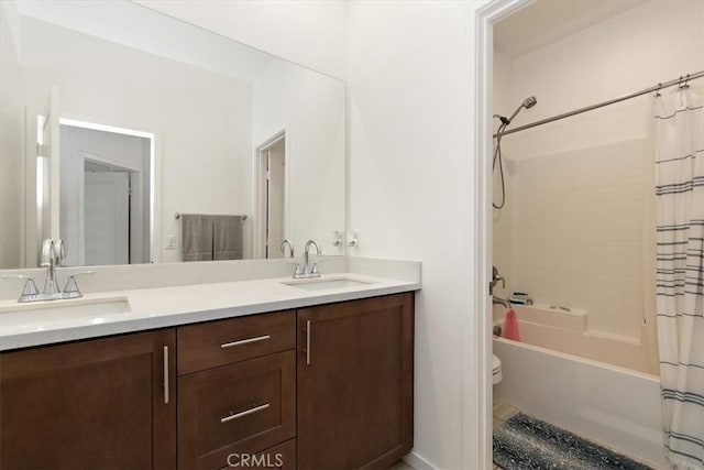 bathroom with a sink, shower / bath combo with shower curtain, toilet, and double vanity