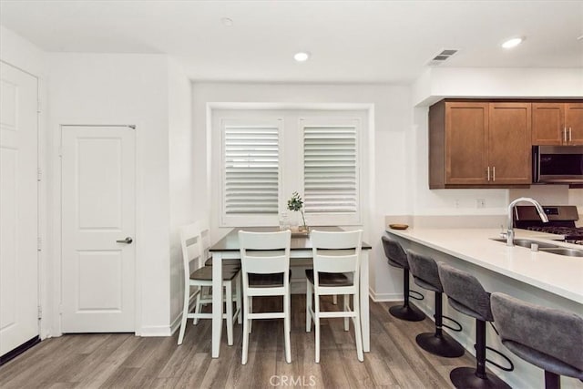 dining area featuring baseboards, recessed lighting, wood finished floors, and visible vents