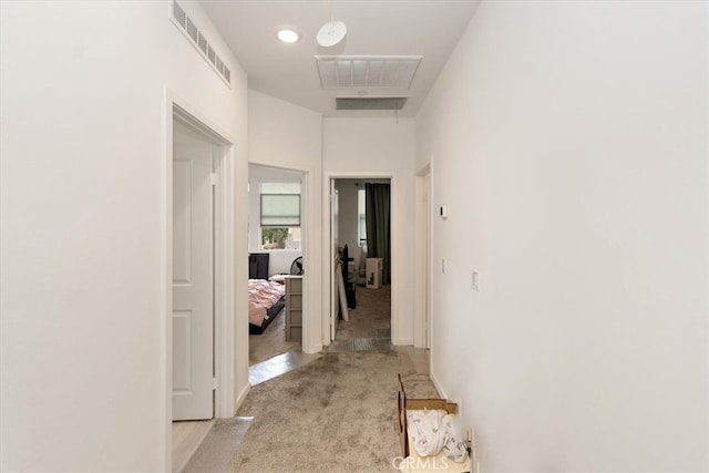 corridor featuring visible vents and light colored carpet