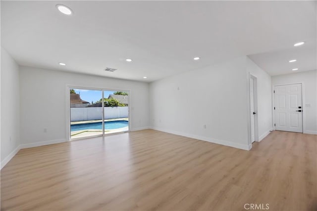 unfurnished room with visible vents, light wood-type flooring, recessed lighting, and baseboards