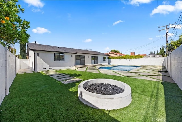 back of property with a patio, a fenced backyard, a fenced in pool, and a lawn