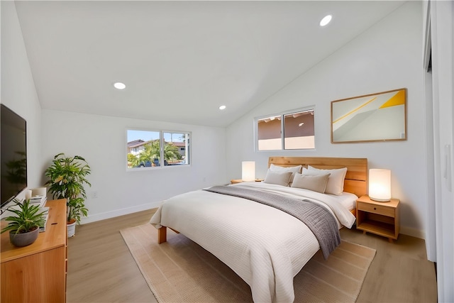 bedroom with lofted ceiling, recessed lighting, light wood-style flooring, and baseboards