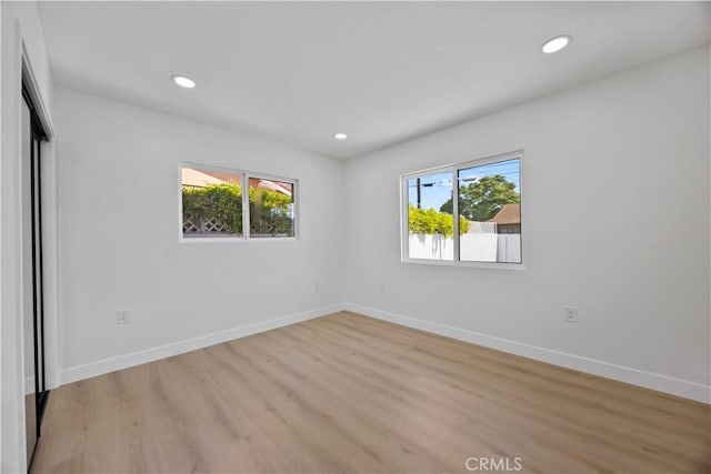 unfurnished room featuring recessed lighting, baseboards, and light wood-type flooring