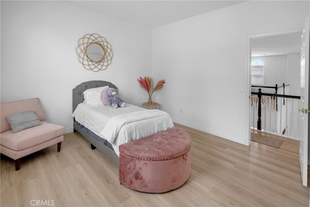 bedroom featuring baseboards and light wood-style flooring