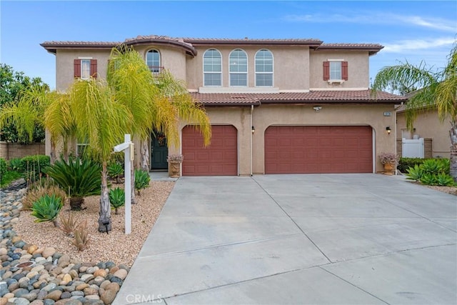 mediterranean / spanish-style home with stucco siding, concrete driveway, and a garage