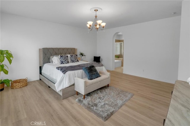bedroom featuring arched walkways, baseboards, a chandelier, and wood finished floors