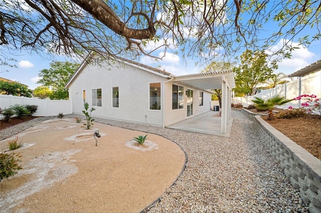 rear view of property featuring a fenced backyard, stucco siding, a tiled roof, a patio area, and a pergola