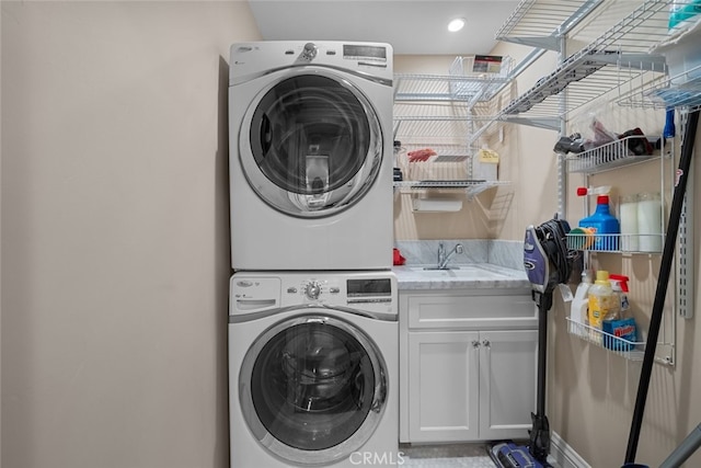 24848 Matterhorn Ct, Crestline, CA 92325 - laundry area featuring a sink, stacked washer and clothes dryer, and cabinet space