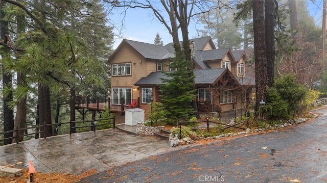 24848 Matterhorn Ct, Crestline, CA 92325 - view of front facade with a deck and roof with shingles