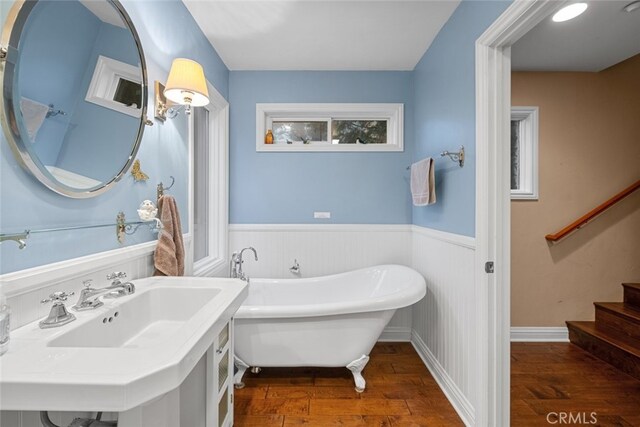 24848 Matterhorn Ct, Crestline, CA 92325 - bathroom featuring wainscoting, a freestanding bath, wood-type flooring, and a sink
