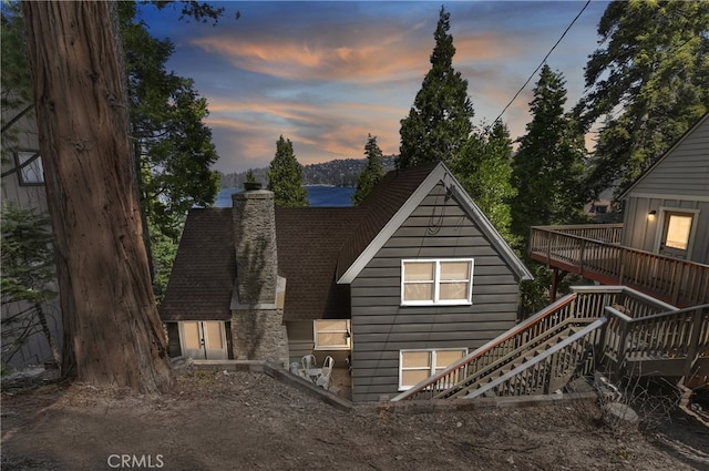 28898 Palisades Dr, Lake Arrowhead, CA 92352 - back of house at dusk featuring a chimney, stairway, and a wooden deck