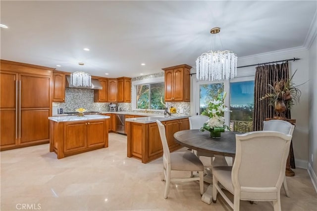 kitchen featuring brown cabinets, decorative backsplash, light countertops, a center island, and a notable chandelier