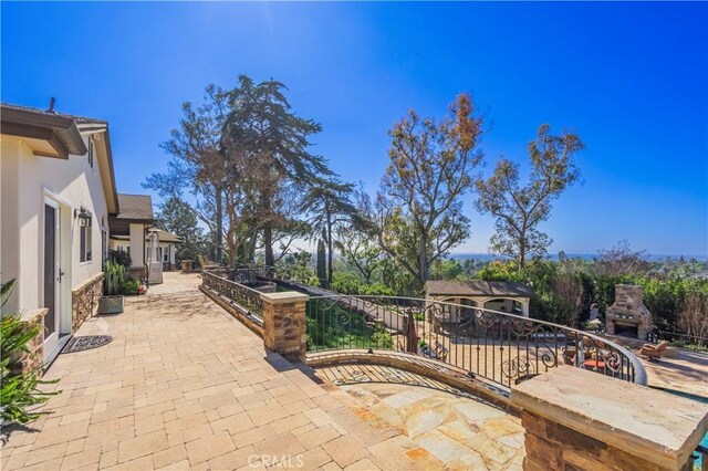 view of patio / terrace featuring an outdoor stone fireplace