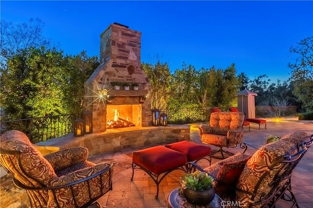 view of patio / terrace featuring fence and an outdoor living space with a fireplace