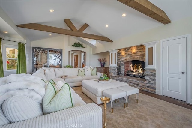 living area featuring recessed lighting, lofted ceiling with beams, decorative columns, a stone fireplace, and wood finished floors