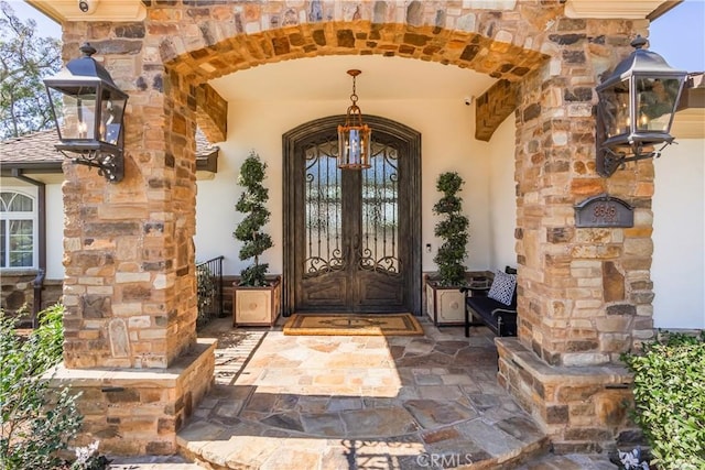 view of exterior entry with stucco siding and stone siding