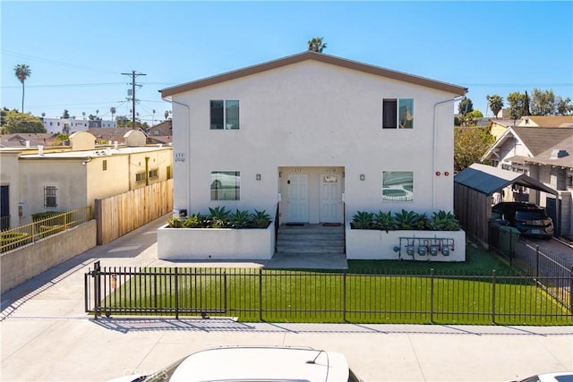 632 W 79th St, Los Angeles, CA 90044 - rear view of house with stucco siding, a yard, a residential view, and a fenced front yard