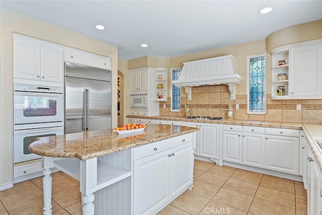28 Malibu, Irvine, CA 92602 - kitchen with open shelves, built in appliances, custom range hood, white cabinetry, and recessed lighting