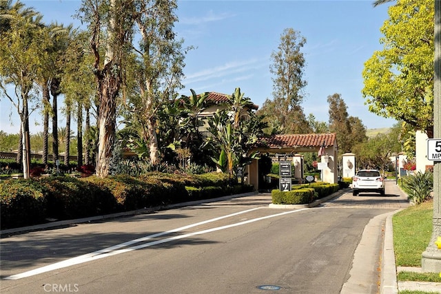 view of street with curbs and a gated entry