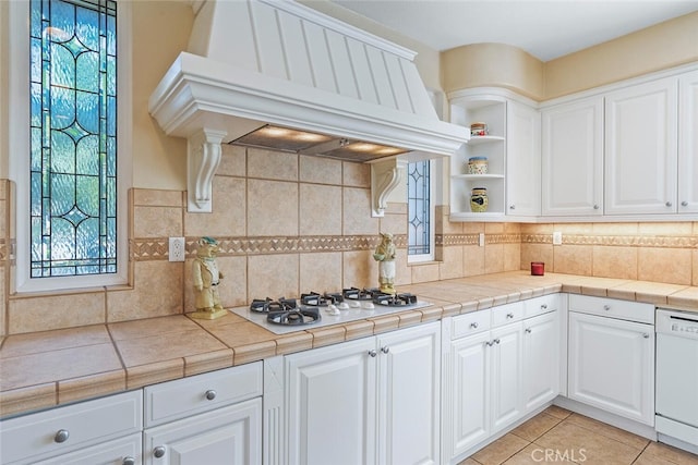 28 Malibu, Irvine, CA 92602 - kitchen with premium range hood, white appliances, white cabinetry, and backsplash