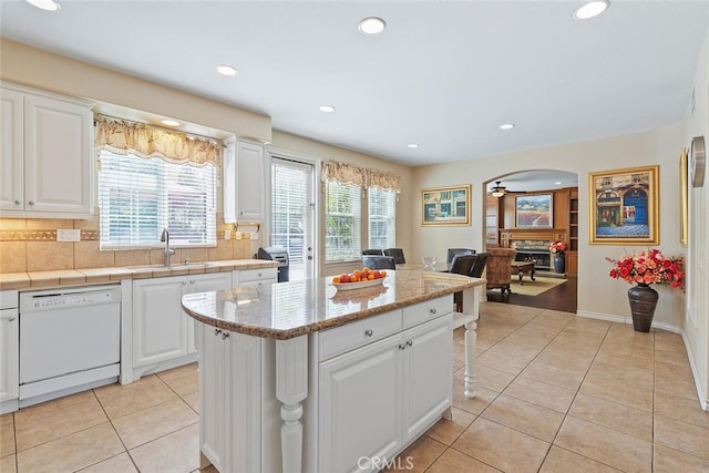 28 Malibu, Irvine, CA 92602 - kitchen featuring white dishwasher, plenty of natural light, light tile patterned floors, arched walkways, and recessed lighting