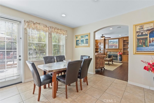 28 Malibu, Irvine, CA 92602 - dining area with a stone fireplace, ceiling fan, light tile patterned floors, arched walkways, and recessed lighting