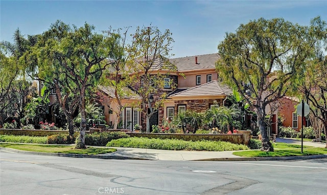 28 Malibu, Irvine, CA 92602 - view of front facade with a tile roof, stone siding, and stucco siding