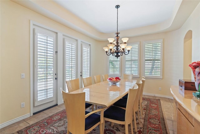 28 Malibu, Irvine, CA 92602 - dining space featuring a chandelier, arched walkways, light tile patterned flooring, and a raised ceiling