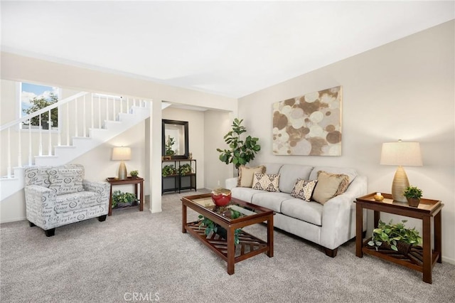 carpeted living area featuring stairway