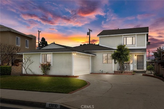 traditional home with driveway, covered porch, stucco siding, a front lawn, and a garage