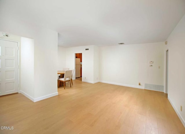 spare room with baseboards, visible vents, and light wood-style floors
