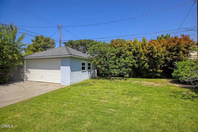 view of yard featuring fence, an outdoor structure, and a detached garage