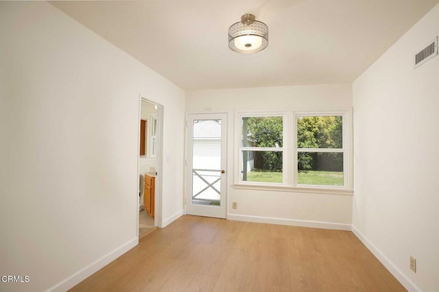 doorway featuring visible vents, light wood-style flooring, and baseboards