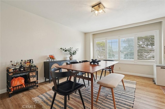 dining room featuring baseboards and light wood-type flooring