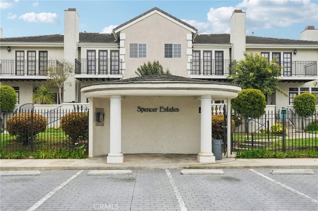 exterior space featuring uncovered parking, stucco siding, and fence