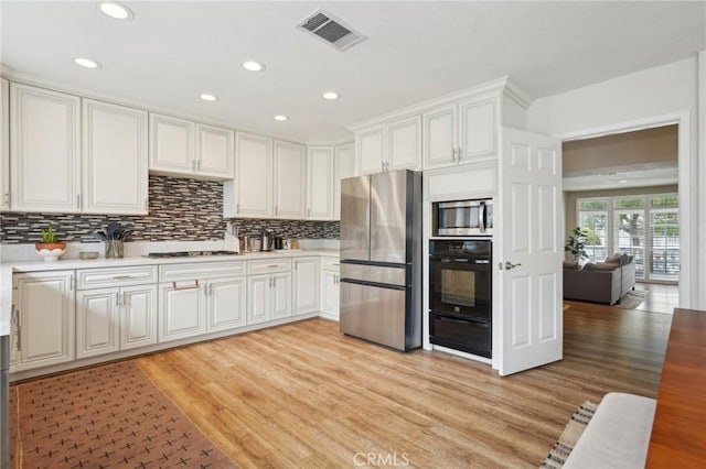 kitchen featuring appliances with stainless steel finishes, visible vents, light wood-type flooring, and light countertops