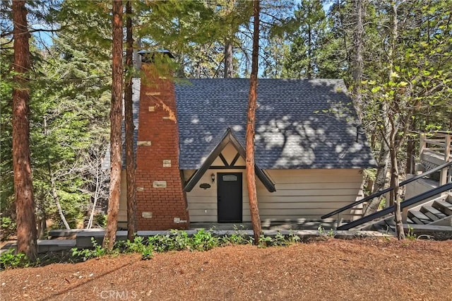 377 Hillside Rd, Lake Arrowhead, CA 92352 - view of front facade featuring roof with shingles, a chimney, and stairs