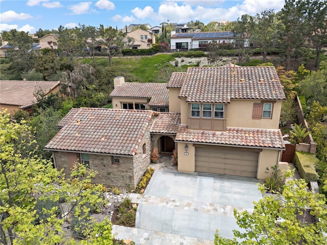 view of front of home featuring a chimney, stucco siding, and a tile roof